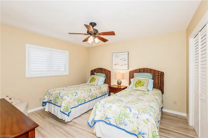 Bedroom featuring ceiling fan, a closet, wood finished floors, and baseboards