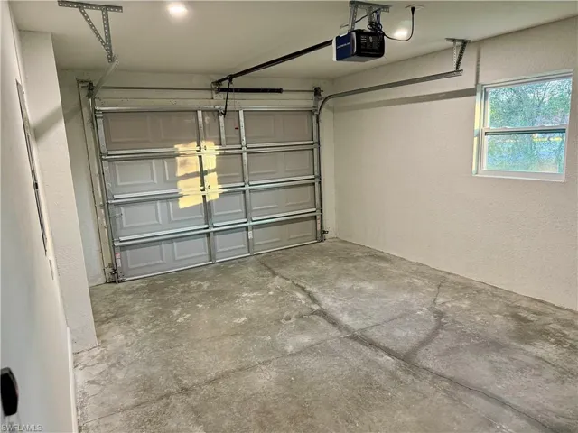 Garage featuring a textured wall and a garage door opener