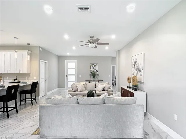 Living room with ceiling fan and light tile flooring