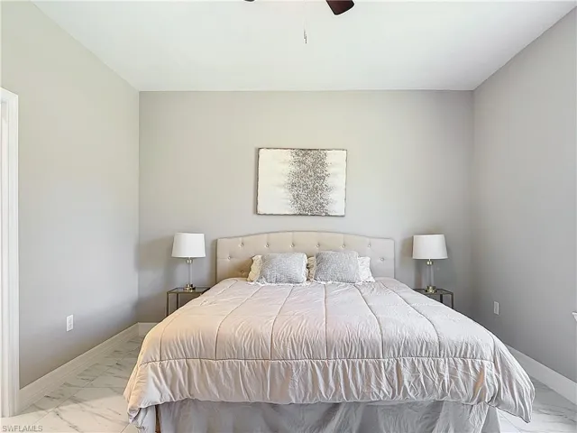 Bedroom with ceiling fan and light tile floors