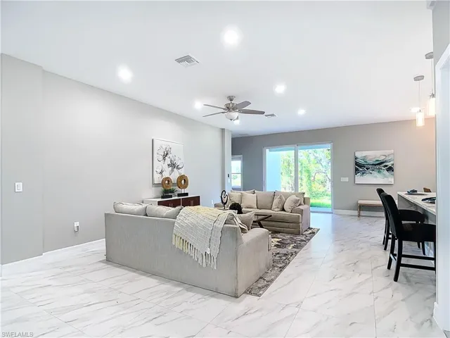 Living room featuring ceiling fan and light tile floors