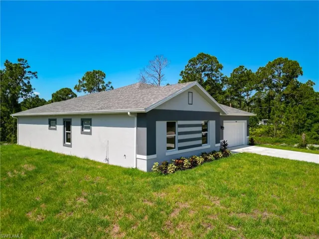 View of front facade featuring a garage and a front yard