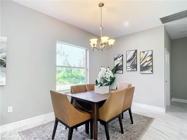 Dining area featuring a chandelier and light tile flooring