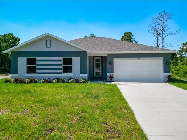 Single story home featuring a front yard and a garage