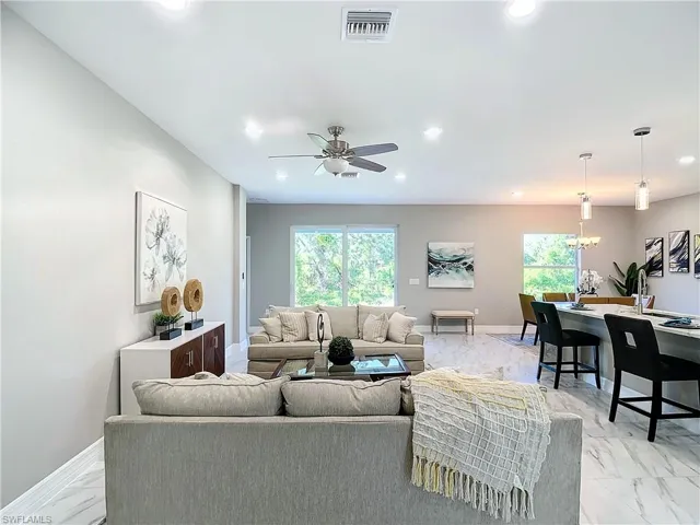 Tiled living room with a wealth of natural light and ceiling fan
