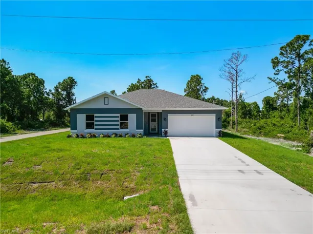 Ranch-style house with a garage and a front lawn