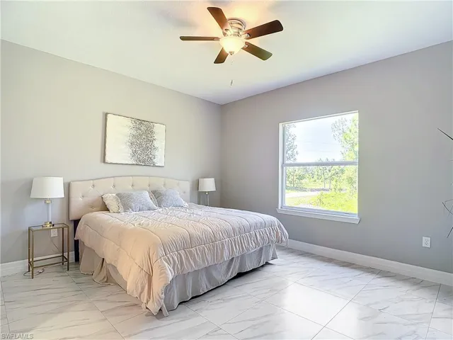 Tiled bedroom featuring ceiling fan