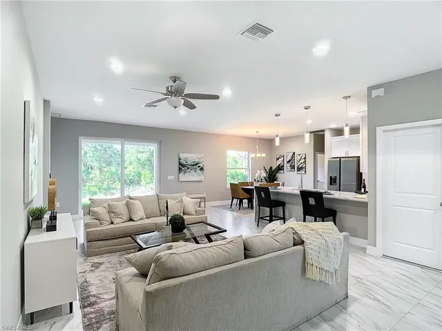 Living room with ceiling fan and light tile flooring