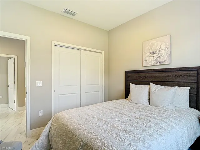 Bedroom with a closet and light tile flooring
