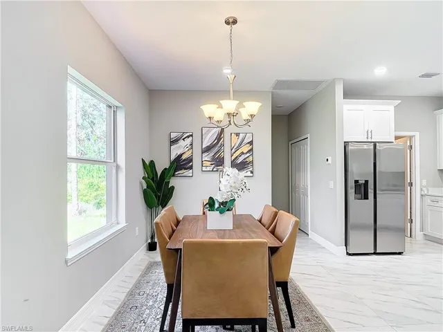Dining area featuring plenty of natural light, a chandelier, and light tile floors
