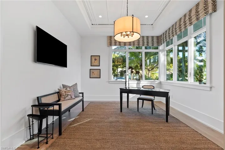 Office space with wood-type flooring and a raised ceiling