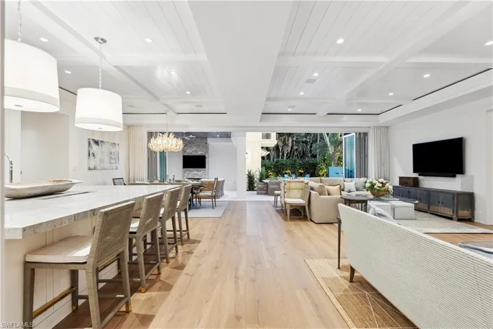 Living room with beam ceiling, coffered ceiling, and light hardwood / wood-style floors