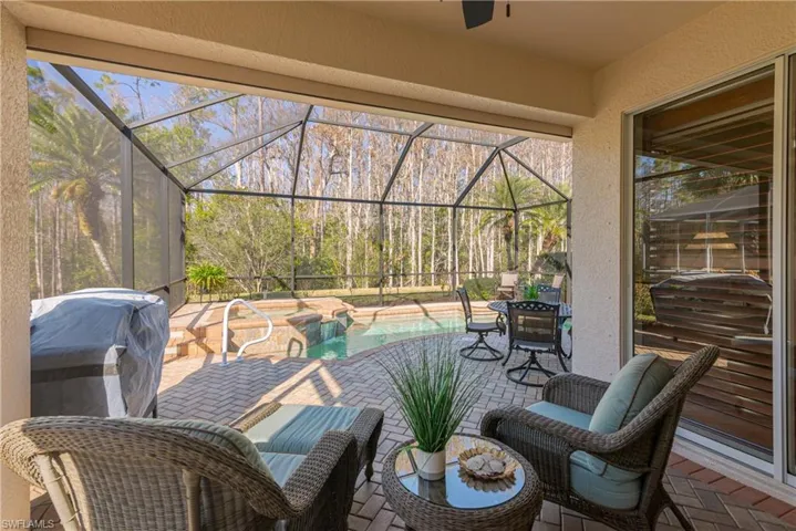 View of patio featuring a sunroom, an outdoor pool, a lanai, and a grill