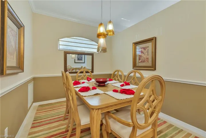 Dining space featuring crown molding and light colored carpet