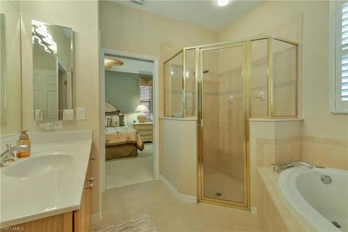 Ensuite bathroom with vanity, a stall shower, a garden tub, and light tile patterned flooring