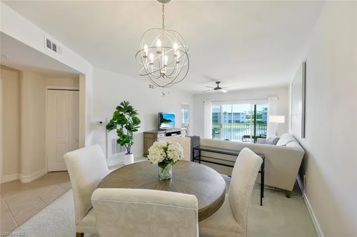 Dining room featuring light tile floors and ceiling fan with notable chandelier