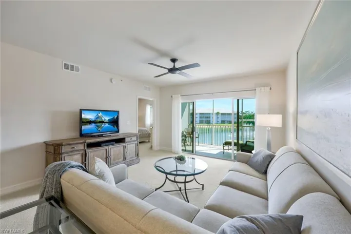 Carpeted living room featuring ceiling fan