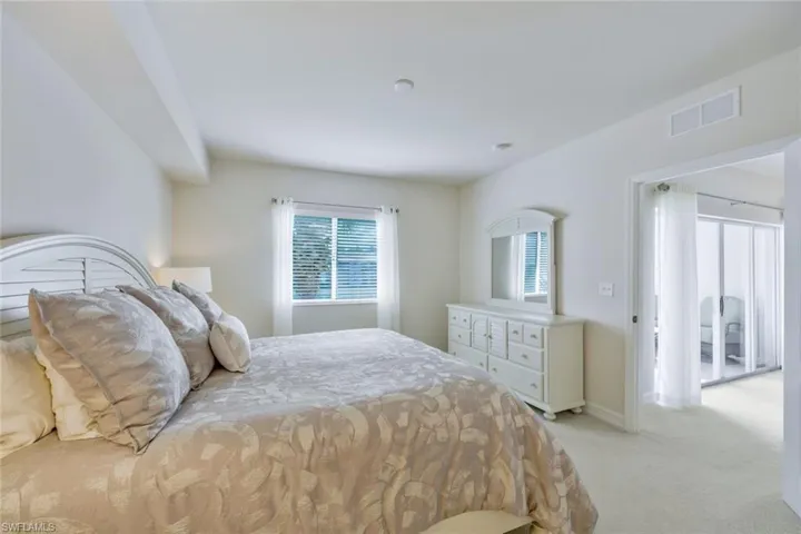 Bedroom featuring multiple windows and light colored carpet