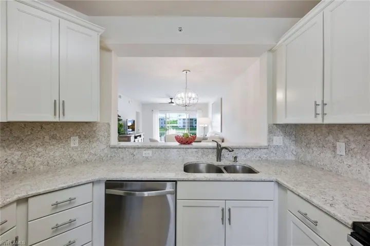 Kitchen with sink, dishwasher, tasteful backsplash, and a chandelier