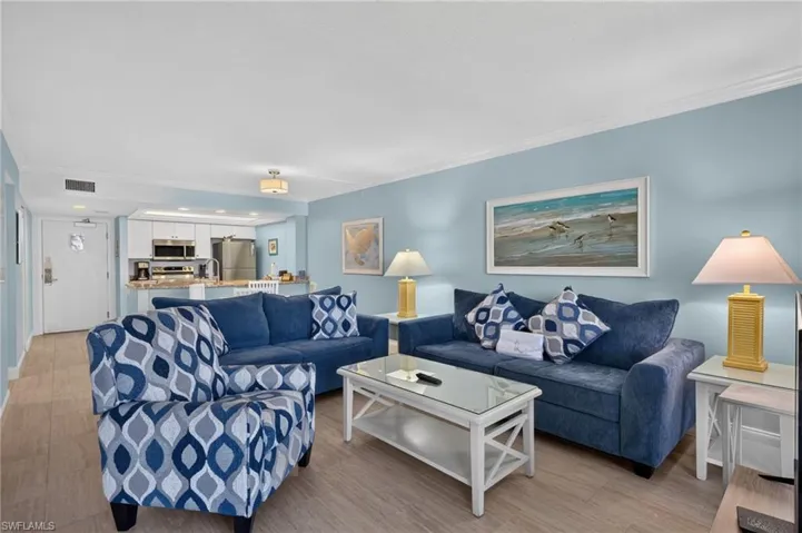 Open-concept living area featuring light wood-finish flooring, light blue wall tones, and recessed lighting