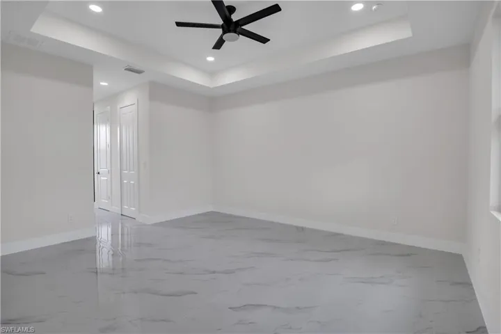 Spare room with ceiling fan and a raised ceiling