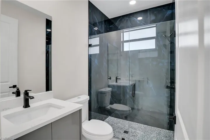 Bathroom with vanity, toilet, and walk in shower