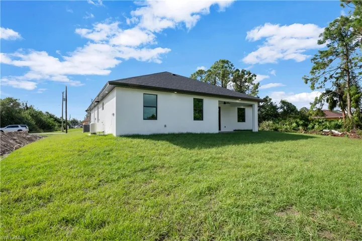 Rear view of house featuring a yard