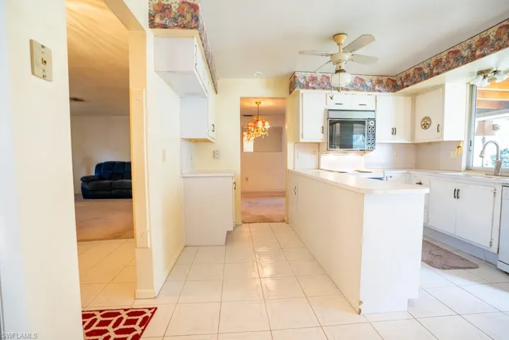 Bright and airy eat-in kitchen with island with window and sliders to Florida room.