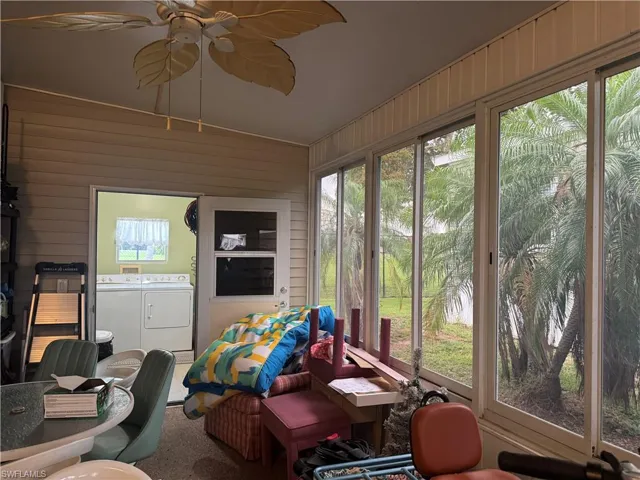 Enclosed patio featuring floor-to-ceiling windows, a ceiling fan with leaf-shaped blades, and direct access to an interior space with a window