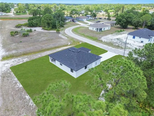 Aerial perspective of a single-story residence featuring a dark shingle roof and light-colored siding