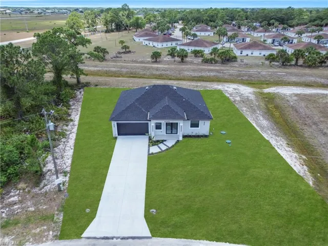 Modern single-story residence featuring a dark shingle roof and light-toned siding