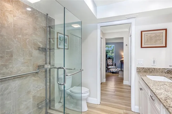Updated Primary Bathroom with walk-in shower and seamless glass shower enclosure.
