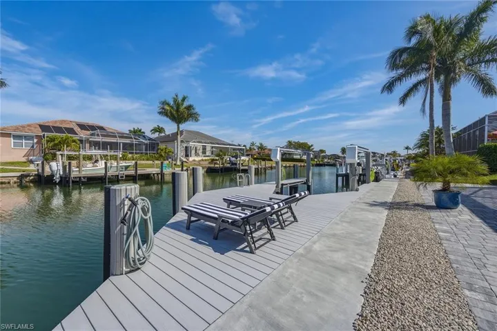 Dock area with a water view, a residential view, and boat lift