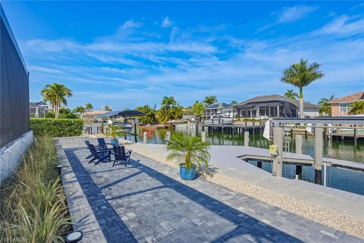 Dock with a water view, boat lift, and a residential view