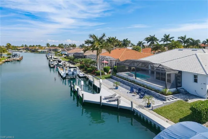 Dock featuring an outdoor pool, a lanai, a water view, a sunroom, and a patio