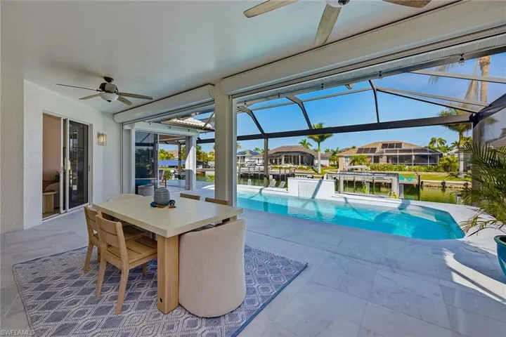 Outdoor pool featuring outdoor dining space, a patio, a sunroom, and a residential view
