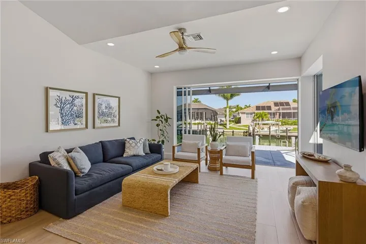 Living area with a ceiling fan, light wood-type flooring, recessed lighting, and a residential view