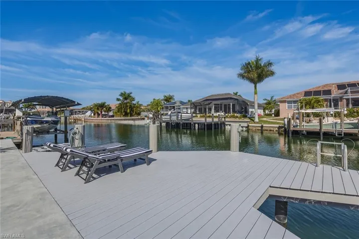 Dock with a water view, boat lift, and a residential view