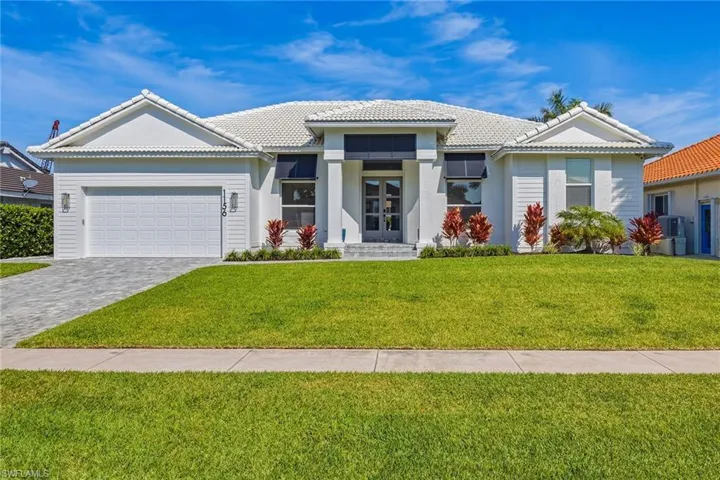 View of front of home featuring french doors, a front lawn, an attached garage, decorative driveway, and a tile roof