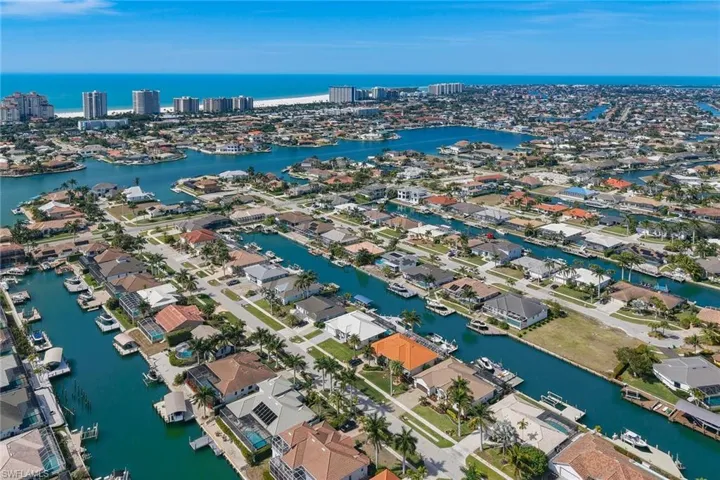 Aerial view of property and surrounding area with a large body of water and nearby suburban area