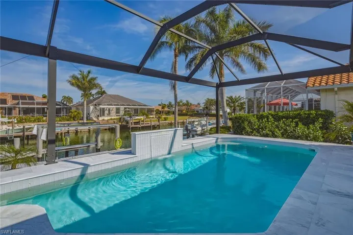 Outdoor pool with a sunroom, a dock, a lanai, a water view, and boat lift