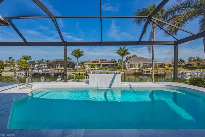 Outdoor pool with a residential view, a water view, a boat dock, and a sunroom