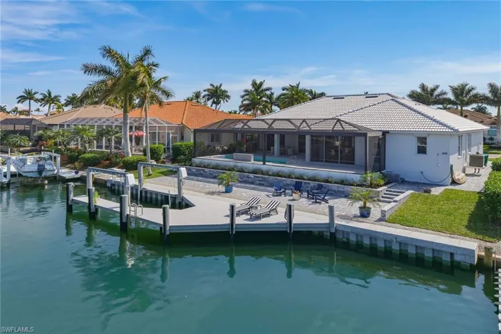 Back of house with a patio area, a water view, a sunroom, a tiled roof, and a lanai