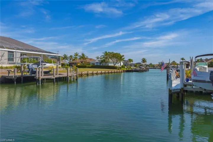 Dock featuring boat lift, a water view, and a residential view