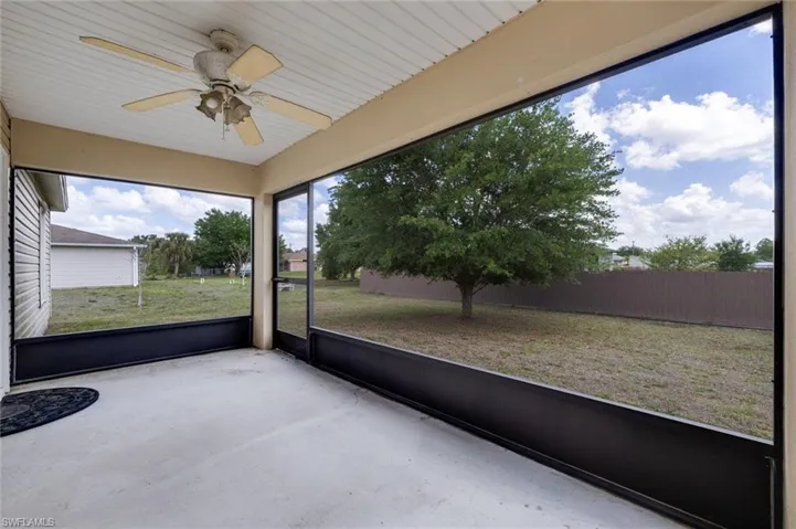 Unfurnished sunroom featuring ceiling fan