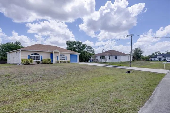 Ranch-style house with a front lawn, concrete driveway, and a garage