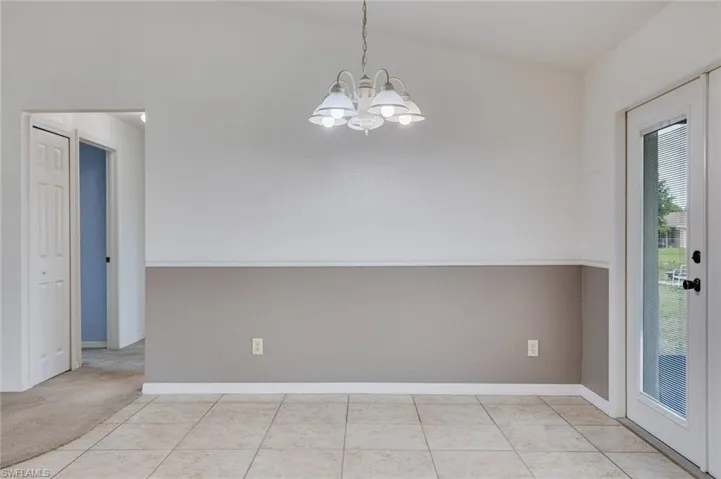 Unfurnished dining area with a chandelier and light tile patterned floors
