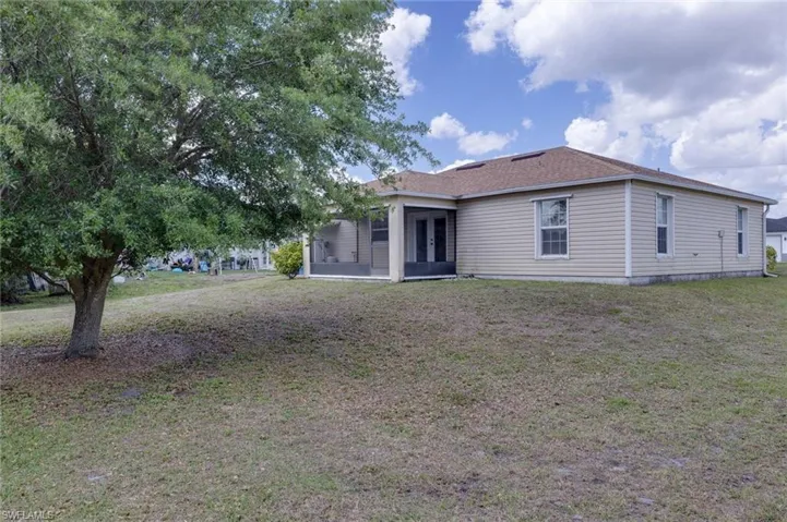 Back of house featuring a sunroom and a yard