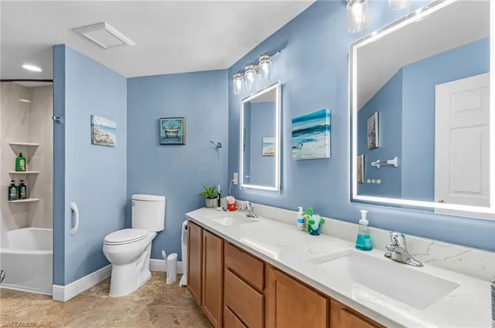 Bathroom with double vanity and tub / shower combination