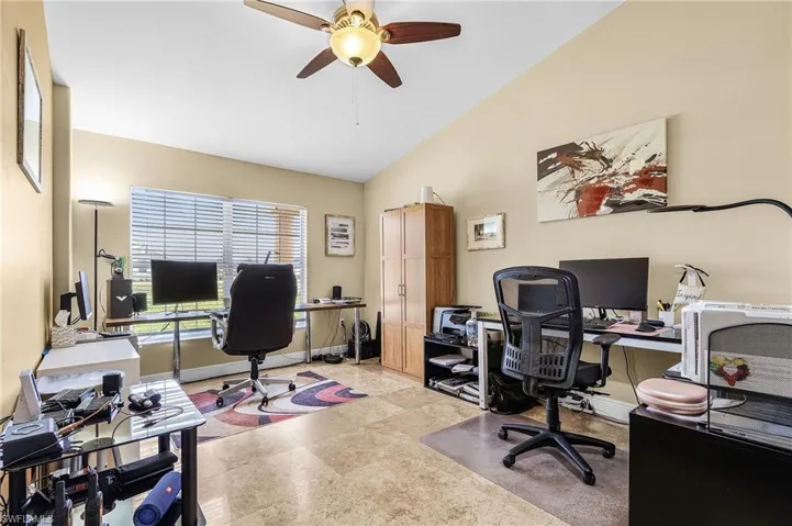 Home office with ceiling fan and vaulted ceiling
